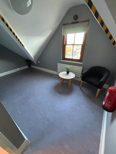 an attic room with a table and a chair at Llety Glyndwr - Bunkhouse in Trawsfynydd