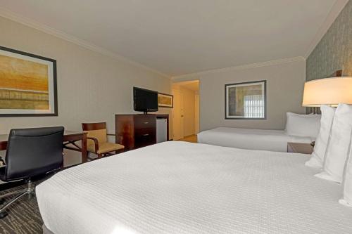 a hotel room with two beds and a television at Best Western Plus Carriage Inn in Sherman Oaks