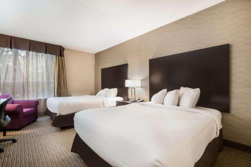 a hotel room with two beds and a purple chair at Best Western Little River Inn in Simcoe