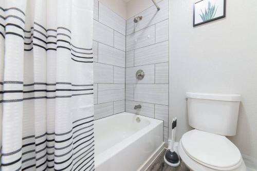 a bathroom with a toilet and a shower curtain at Walk to ATT-Glblife-Free Parking-Min to attraction in Arlington