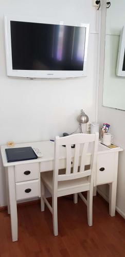 a white desk with two chairs and a tv on a wall at Best Western Hotel Apollo in Oulu