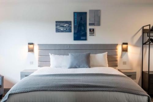 a bedroom with a large bed with two lights on it at The Bolton Stadium Hotel, a member of Radisson Individuals in Bolton
