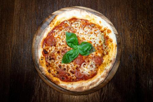 a pizza sitting on top of a wooden table at The Bolton Stadium Hotel, a member of Radisson Individuals in Bolton