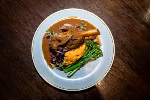 a plate of food with meat and broccoli on a table at The Bolton Stadium Hotel, a member of Radisson Individuals in Bolton