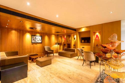 a living room with chairs and a couch and tables at Svelte Delhi, a member of Radisson Individuals in New Delhi