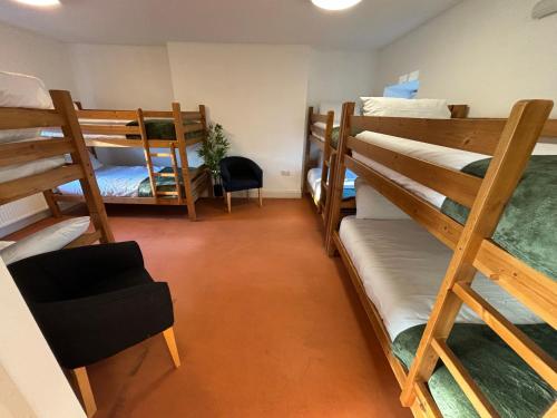 a room with several bunk beds in a room at Llety Glyndwr - Bunkhouse in Trawsfynydd