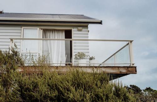 a house with a balcony on the side of it at Sailor's Catch in Hokitika