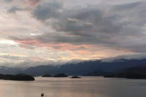 a cloudy sky over a large body of water at A casa da Lua in Paraty
