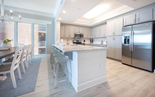 a kitchen with a large island with a stainless steel refrigerator at Phoenix Gulf Towers 405 condo in Gulf Shores