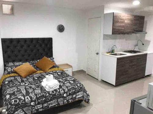 a bedroom with a bed and a kitchen with a sink at Hotel Orduz Centro Histórico de Cali in Cali
