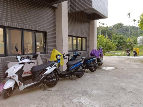 a group of scooters parked outside of a building at 長龍客棧 in Nantou City