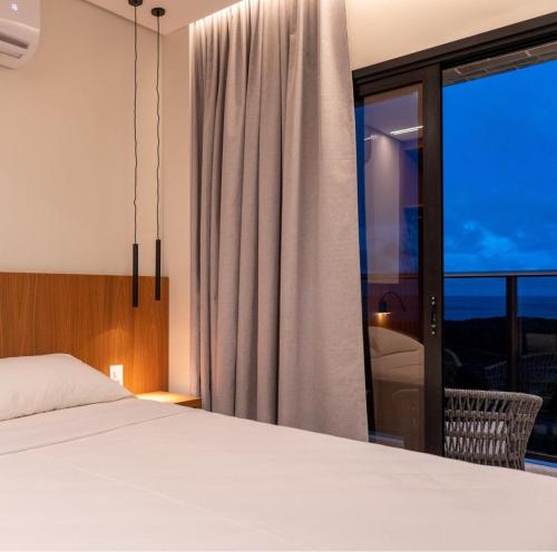 a bedroom with a bed and a large window at Hotel Resort em Salinópolis in Salinópolis