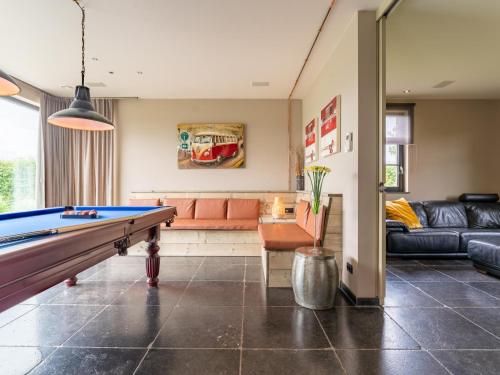 a living room with a pool table and a couch at Villa Meersen in Maldegem