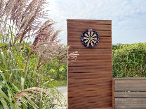a clock on the side of a wooden wall at Villa Meersen in Maldegem