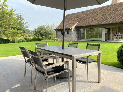 a table and chairs with an umbrella on a patio at Villa Meersen in Maldegem