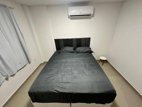 a bedroom with a large bed in a white room at Apto 2 quartos perto da praia in Rio de Janeiro