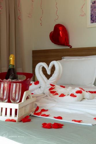 a bed with a bottle of wine and a swan decoration at Rede Andrade Solmar in João Pessoa
