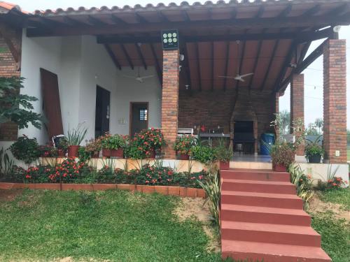 a house with a porch and a red staircase at Casa Quinta Sagrada Familia de Nazaret in Guarambaré
