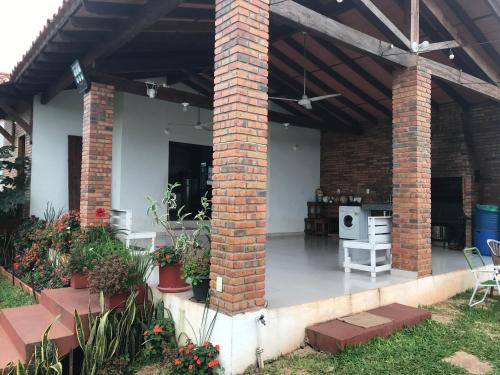 a brick house with a patio with flowers and plants at Casa Quinta Sagrada Familia de Nazaret in Guarambaré