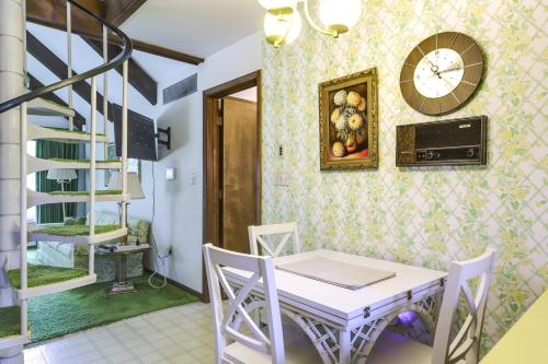 a dining room with a table and chairs and a clock on the wall at Retro Ohio Home on 1-Acre Property in Xenia