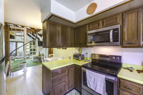 a kitchen with wooden cabinets and a microwave at Retro Ohio Home on 1-Acre Property in Xenia