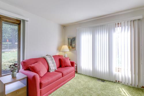 a red couch in a living room with a window at Retro Ohio Home on 1-Acre Property in Xenia