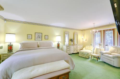 a bedroom with a large white bed and a chair at Retro Ohio Home on 1-Acre Property in Xenia