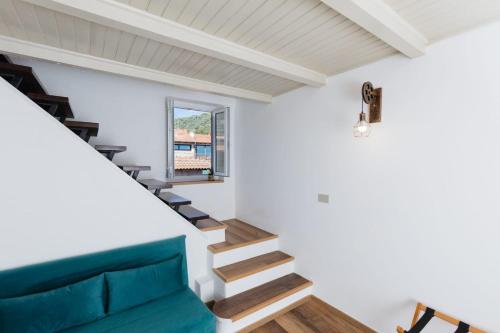 a staircase in a house with a blue couch at A ca de DANTE in Dolceacqua