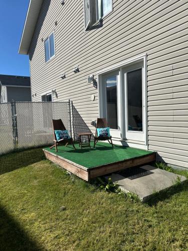 two chairs sitting on a deck next to a house at Easystay in Fairbanks