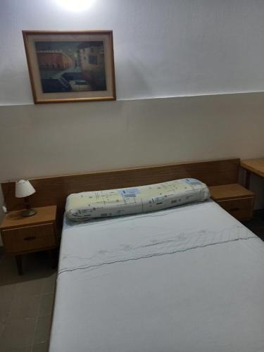 a bedroom with a bed and a picture on the wall at Hotel Florentino in Buenos Aires