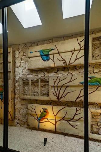 a stone wall with two birds painted on it at Casa Clementina Luxe Rustic Haven 5 star Location in Mérida