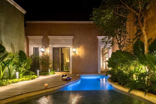a swimming pool in the middle of a garden at night at Casa Clementina Luxe Rustic Haven 5 star Location in Mérida