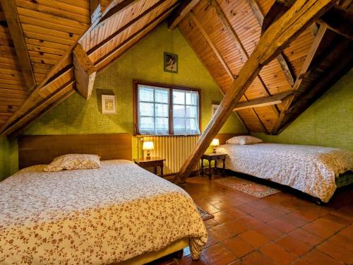Cet hébergement comprend 2 lits dans une chambre dotée de murs verts et de plafonds en bois. dans l'établissement Gîte chaleureux au cœur du Berry, proche Château de Valençay et Zoo de Beauval, jardin clos et calme - FR-1-591-33, à Gehée