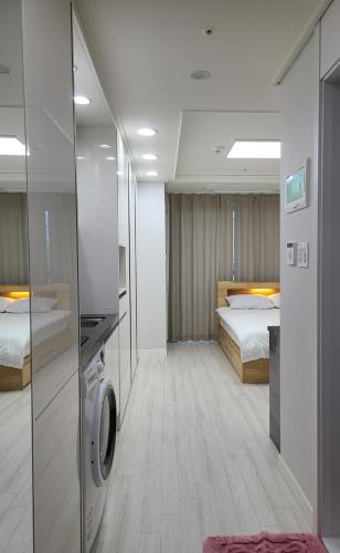 仁川にあるCentral City 6のベッド2台、洗濯機が備わるアパートメントです。