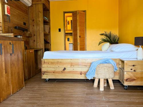 a bedroom with a large bed in a yellow room at Jan Kok Lodges in Willibrordus