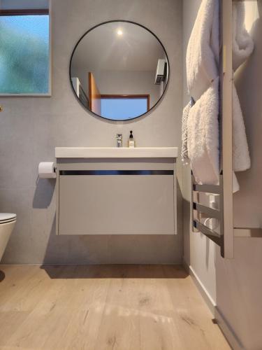 ein Badezimmer mit Waschbecken und Spiegel in der Unterkunft Picton Paradise Cottages in Picton