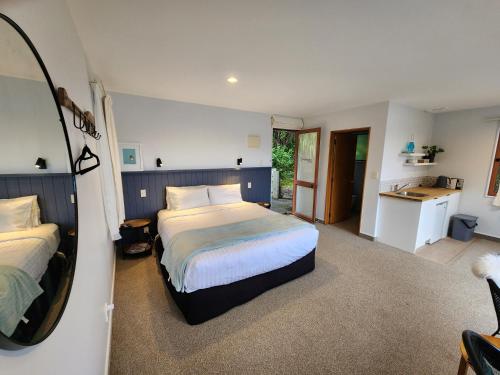 ein Schlafzimmer mit zwei Betten und einem Spiegel in der Unterkunft Picton Paradise Cottages in Picton