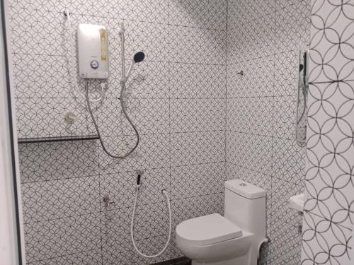 a bathroom with a shower with a toilet and a phone at Perhentian Bay Chalet in Perhentian Island