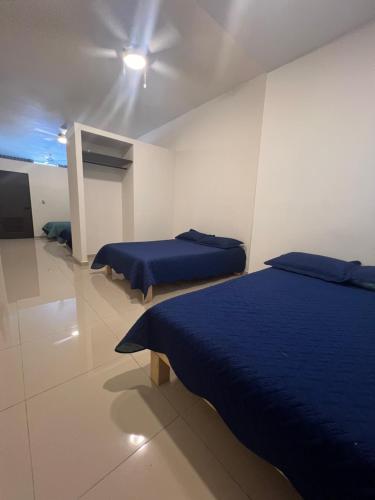 a bedroom with two beds and a ceiling fan at Suites Mar de Cortes in Mazatlán