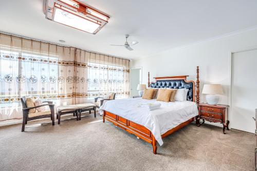a bedroom with a large bed and a table and chairs at StayAU 5BR Idyllic Lakefront Escape Point Cook in Point Cook