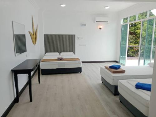 a bedroom with two beds and a desk in it at Perhentian Bay Chalet in Perhentian Island