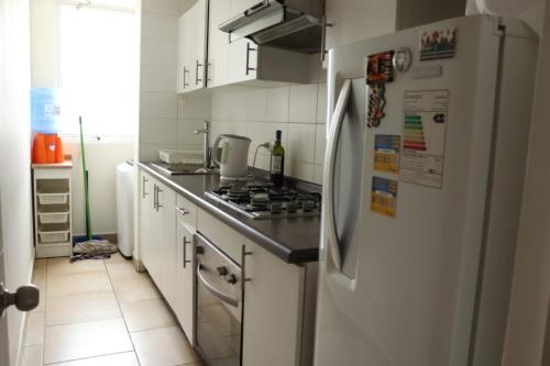 una cucina con elettrodomestici bianchi e frigorifero bianco di Departamento con 3 habitaciones para 4 personas playa la Herradura a Coquimbo