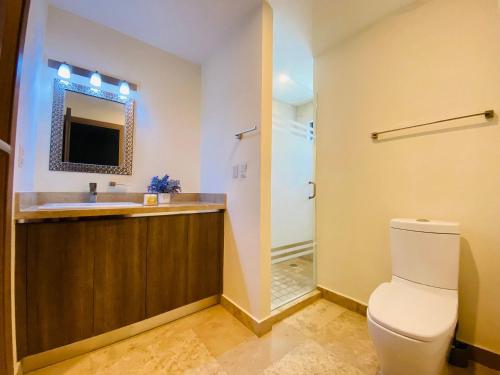 ein Badezimmer mit Toilette, Waschbecken und Spiegel in der Unterkunft Torre Central 102: Malecón, Lujo y Vistas de ensueño. in Mazatlán