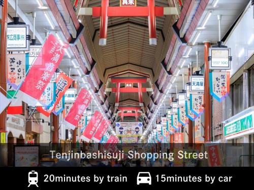 a view of a shopping mall with signs and flags at MERBABU STAY OSAKA in Osaka
