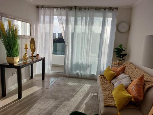 a living room with a couch and a large window at Sunrise in La Serena