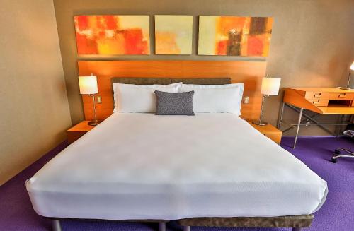 a large white bed in a room with two lamps at Camino Real Santa Fe in Mexico City