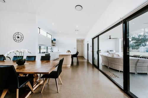 a dining room and living room with a table and chairs at Mudgee Haven - Stunning Terra Modern Design in Mudgee