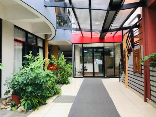 an entrance to a building with plants and a hallway at Palm Beach Hotel Dili in Dili