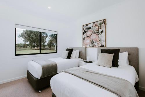 two beds in a room with white walls at Mudgee Haven - Stunning Terra Modern Design in Mudgee