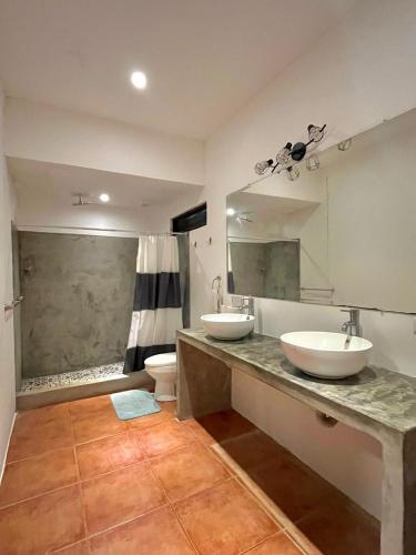 a bathroom with two sinks and a toilet at Tamarindo Backpackers in Tamarindo